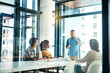 © BuyoutReese06/peopleimages.com - Boardroom, explain and presentation with designer people in workplace together for coaching or update. Collaboration, meeting and upskill development with employee group in glass office for training