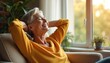 © miss irine - Smiling senior woman relaxes on sofa in sunlit room, hands behind head, enjoying peaceful weekend. Contented elderly lady feels happy, stress-free, breathing fresh air, taking a rest.