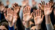 © uzii - Upward reaching hands of young adults in a lecture hall showing active engagement and participation in a discussion