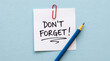 © Ajay - Don’t forget reminder note concept with paper clip and pencil on blue background representing memory alert task planning organization and daily productivity.