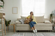 © New Africa - Woman with her cute dog relaxing on sofa at home