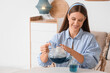 © Pixel-Shot - Beautiful young woman pouring organic blue tea into cup at home