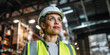 © Nexa - Confident female warehouse manager in white hard hat and safety vest standing in industrial distribution center.