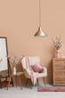 © Pixel-Shot - Armchair with dresser, mirror and vases of blooming branches near beige wall in living room