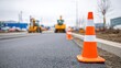 © Alex - Construction Zone with Traffic Cones and Equipment on a Newly Paved Road Under Overcast Skies, Highlighting Urban Infrastructure Development