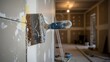 © 511 - A rusty drywall putty knife with a blue handle, applying joint compound to a wall during interior renovation.