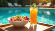© Pete - Healthy breakfast bowl with fruit and orange juice served poolside on a sunny day. Enjoying light meal by swimming pool and lounge chairs. Refreshing food and drink for vacation.