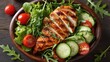 © mila103 - Grilled chicken salad with lettuce, arugula, cherry tomatoes, and cucumber.