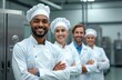 © Viktor - Diverse food production team in white coats and hats smile proudly in modern factory setting. Professionals cross arms looking at camera with confidence. Collaboration, expertise, and quality control.
