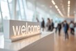© Jaynal - Stunning photo of Modern illuminated welcome sign on a white reception desk in a blurred corporate office lobby or event hall