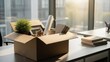 © Photo Moon - Office relocation cardboard box with personal belongings plant mug and documents on modern workplace desk during corporate moving day