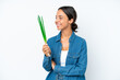 © luismolinero - Young hispanic woman holding chive isolated on white background looking side