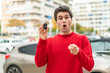 © luismolinero - Young handsome man with car key surprised and pointing front