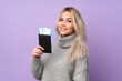 © luismolinero - Teenager girl over isolated purple background happy in vacation with passport and plane tickets