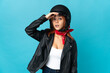 © luismolinero - Teenager biker girl isolated on blue background doing surprise gesture while looking to the side