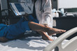 © Ketnapa - Doctor examining and supporting injured ankle of female patient in hospital room, providing medical assistance and treatment for sprain or fracture