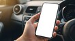 © shakib - Person holding white screen smartphone while driving car, showcasing blank display perfect for app mockups or content placement, focusing on device in hand