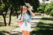 © deagreez - Young woman student outdoors on a sunny day in a park posing with a pink backpack and casual fashion style