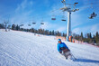 © Alex - A man in a blue jacket confidently skis down a mountain