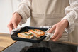© Pixel-Shot - Woman frying tasty steak in kitchen