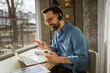 © Miljan Živković - Businessman having video call wearing headset at home office