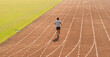 © Q88 - A man runs alone on a track showcasing fitness and determination in a solo practice run