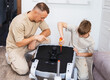 © Aboltin - Parent and child spending quality time at home while assembling furniture together. Supportive parenting, learning by example, family values and warm domestic lifestyle