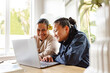 © NZstockphoto - Samoan mum helping teenage daughter with homework using laptop