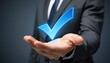 © CrazyJuke - Business Approval: A hand extends, cradling a glowing checkmark, a symbol of confirmation and endorsement in a professional environment.