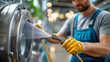 © Nataliya - Man using power hose to clean industrial machine, faceless worker, equipment sanitation, facility maintenance, high-pressure washing, defocused factory background, with copy space