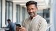 © Ilja - Confident Mature Businessman Using Smartphone in Modern Office with Advanced Business Technologies