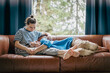 © olezzo - Lesbian couple cuddling on sofa at home, LGBT family and Valentine’s Day concept