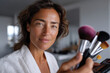 © Milos - A confident woman showcases an array of makeup tools, representing beauty, creativity, and personal expression with a strong visual impact.