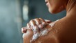 © morepiixel - A close-up of a person washing their shoulder, with soap bubbles visible, capturing a moment of personal care in a shower setting.