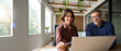 © insta_photos - Two happy busy male and female business people working at desk using laptop computer in office. Professional business colleagues discussing corporate project idea, manager consulting client at meeting