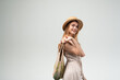 © Volodymyr_sh - Smiling young woman in summer dress and straw hat holding reusable grocery bag, sustainable shopping and healthy lifestyle concept