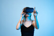 © Volodymyr_sh - Female gamer interacting with virtual objects using VR headset, hand tracking and immersive gaming technology concept