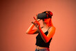 © Volodymyr_sh - Young woman using virtual reality headset and touching digital interface, immersive high technology experience with future innovation concept