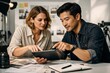 © Loginova - Creative professionals reviewing work on a tablet together in a modern studio environment.