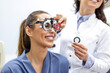 © Graphicroyalty - Eye exam with trial frame and lenses for vision correction. Smiling patient undergoing optometry test with professional ophthalmologist to determine glasses prescription.