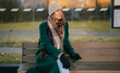 © M-Production - Woman waiting for transport at bus stop.
