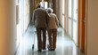 © Jane - Elderly couple walking together in nursing home hallway