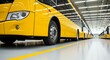 © White Craft  - New yellow buses parked in a factory with bright headlights visible