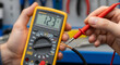 © Mahfud Picture - Close-up of hands using a digital multimeter to measure voltage on exposed electrical wires. Essential diagnostic testing for system safety and functionality