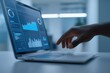 © misunderst00d - Hand interacting with modern laptop displaying business intelligence charts and graphs, representing data analysis, technology, and financial review in office setting
