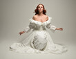 © faestock - full length portrait beautiful female model wearing historical white fantasy wedding dress, fairytale ball gown. isolated figure sitting pose, hands gesturing  on white studio