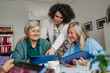© Halfpoint - Volunteer teaching seniors how to work with digital tablet.