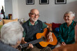 © Halfpoint - Senior man playing guitar in retirement home.