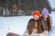 © Halfpoint - Sisters sledding together and experiencing winter excitement.