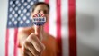 © DawDunia - Person holding i voted today sticker on thumb with an american flag forming a patriotic background, representing civic duty, election, and democratic participation